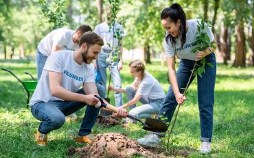 young-volunteers-planting-trees-in-green-park-together.jpg